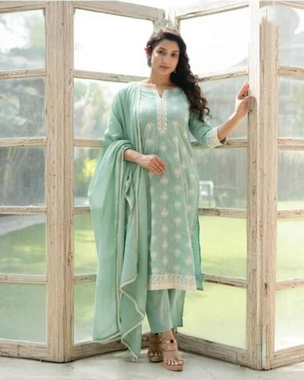 Lady standing in a sea green stitched suit